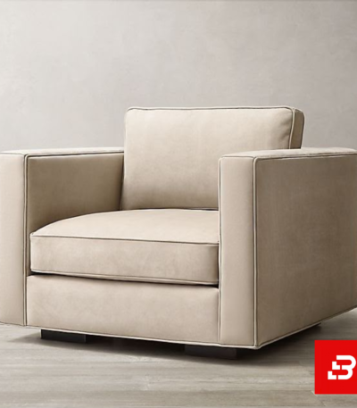 Modern minimalist living room featuring a plush beige velvet square frame armchair with subtle piping details on dark wooden feet by Bahoo Furniture UAE