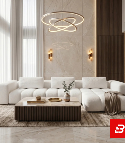 Grand double-height living room interior showcasing a luxury l-shape sectional sofa upholstered in soft off white bouclé fabric with a modern ring chandelier and marble coffee table by Bahoo Furniture UAE