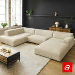 Sophisticated dark interior setting showcasing an expansive beige fabric u-shape sectional sofa against dark grey walls, framed art, and wooden flooring by Bahoo Furniture UAE