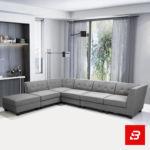 Modern contemporary living room featuring a warm gray fabric button-tufted l-shape sectional sofa set with a matching ottoman and minimalist shelves by Bahoo Furniture UAE