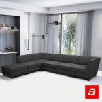 Modern contemporary living room featuring a warm gray fabric button-tufted l-shape sectional sofa set with a matching ottoman and minimalist shelves by Bahoo Furniture UAE