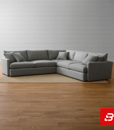 Minimalist living room featuring a warm gray fabric l-shape sectional sofa with plush cushions on a woven rug over wooden flooring by Bahoo Furniture UAE
