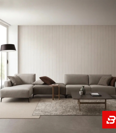Minimalist modern living room interior showcasing a warm gray fabric l-shape sectional sofa against vertical paneled walls, floor lamp, and low wooden coffee table by Bahoo Furniture UAE