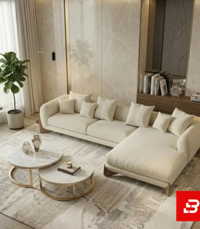 Elegant bright living room interior showcasing a luxury l-shape sectional sofa upholstered in off white bouclé fabric with nesting marble coffee tables and a indoor plant by Bahoo Furniture UAE