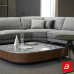 Overhead aerial interior view of a modern minimalist living room featuring a warm gray fabric u-shape sectional sofa styled with colorful accent pillows, a stone-top coffee table, and side accent tables by Bahoo Furniture UAE