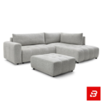 Bright modern living room interior featuring a warm gray fabric tufted l-shape sectional sofa with vertical channel tufting, matching footrest ottoman, and arched window by Bahoo Furniture UAE