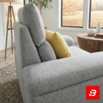 Spacious luxury living room featuring a gray fabric l-shape sectional sofa set with matching ottoman, armchair, and round wooden coffee table by Bahoo Furniture UAE