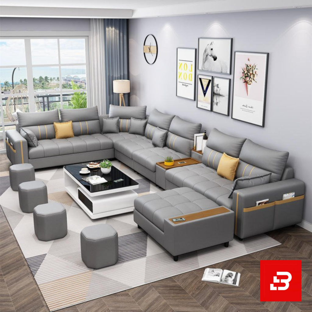 Sleek modern luxury living room interior showcasing an extensive modular sectional sofa upholstered in soft warm gray fabric featuring integrated armrest storage pockets and matching ottomans by Bahoo Furniture UAE