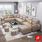 Sleek modern luxury living room interior showcasing an extensive modular sectional sofa upholstered in soft warm gray fabric featuring integrated armrest storage pockets and matching ottomans by Bahoo Furniture UAE