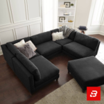 Overhead view of a modern luxury living room interior showcasing a grand u-shape sectional sofa upholstered in soft warm gray textured fabric with plush faux-fur accent pillows and matching ottoman by Bahoo Furniture UAE