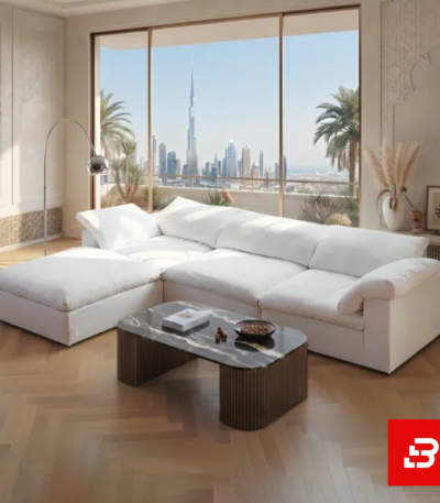 Luxurious modern living room interior showcasing a large luxury modular sofa upholstered in soft off white textured fabric featuring deep cushions and an attached chaise lounge by Bahoo Furniture UAE