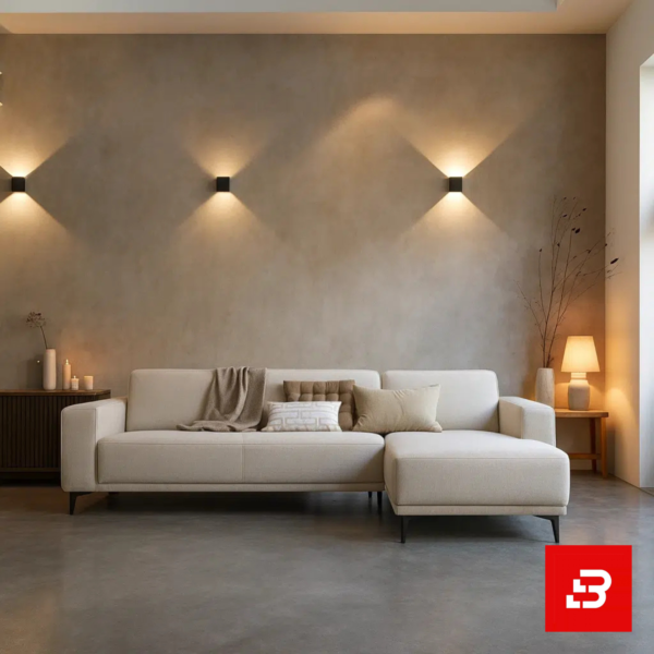 Warm and ambient modern living room interior showcasing a sleek l-shape sectional sofa upholstered in soft beige fabric paired with a matching chaise lounge against textured beige walls by Bahoo Furniture UAE