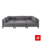 Overhead view of a modern luxury living room interior showcasing a grand u-shape sectional sofa upholstered in soft warm gray textured fabric with plush faux-fur accent pillows and matching ottoman by Bahoo Furniture UAE