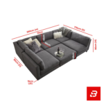 Overhead view of a modern luxury living room interior showcasing a grand u-shape sectional sofa upholstered in soft warm gray textured fabric with plush faux-fur accent pillows and matching ottoman by Bahoo Furniture UAE